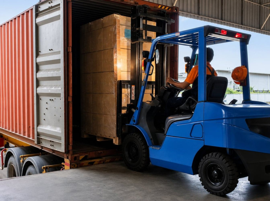 Forklift loading cargo into shipping container for international freight